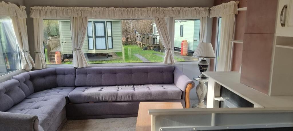 a living room with a purple couch in front of a window at Caravan - Sleeps 8 pet friendly & hot tub in Welshpool