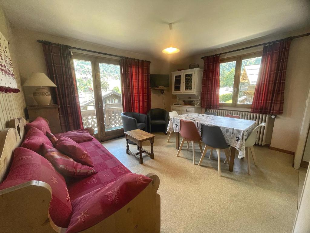 a living room with a couch and a table at Gemeaux B, appartement proche pistes de ski et village in La Clusaz