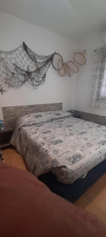 sypialnia z łóżkiem z dwoma pierścieniami na ścianie w obiekcie Appartamento residence Tartaruga 3 w mieście Castelsardo