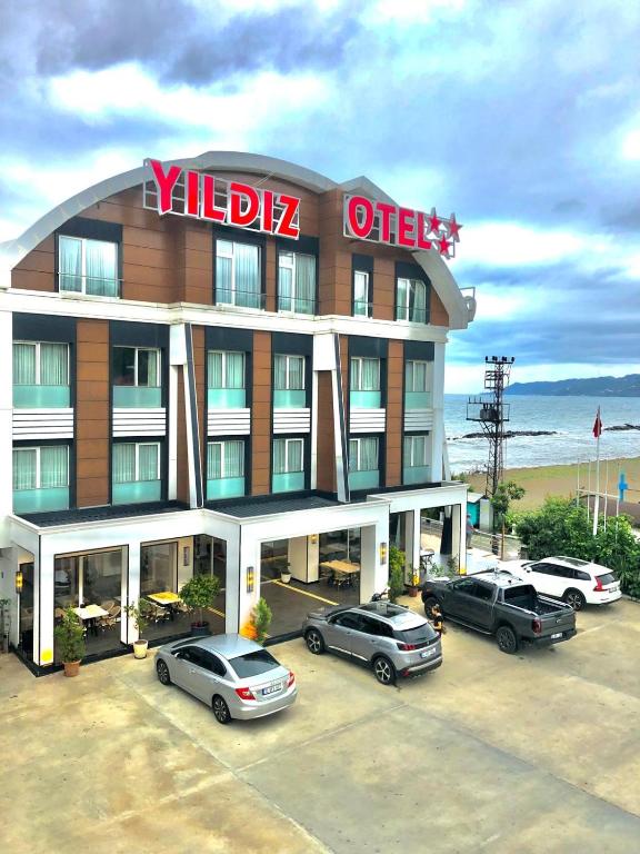 a hotel with cars parked in a parking lot at Yildiz Hotel in Fatsa