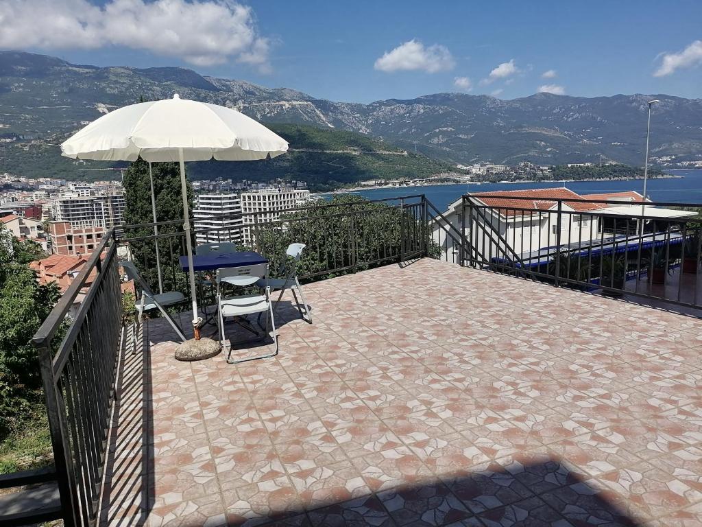 un patio con una mesa y una sombrilla en Guest House Garden, en Budva