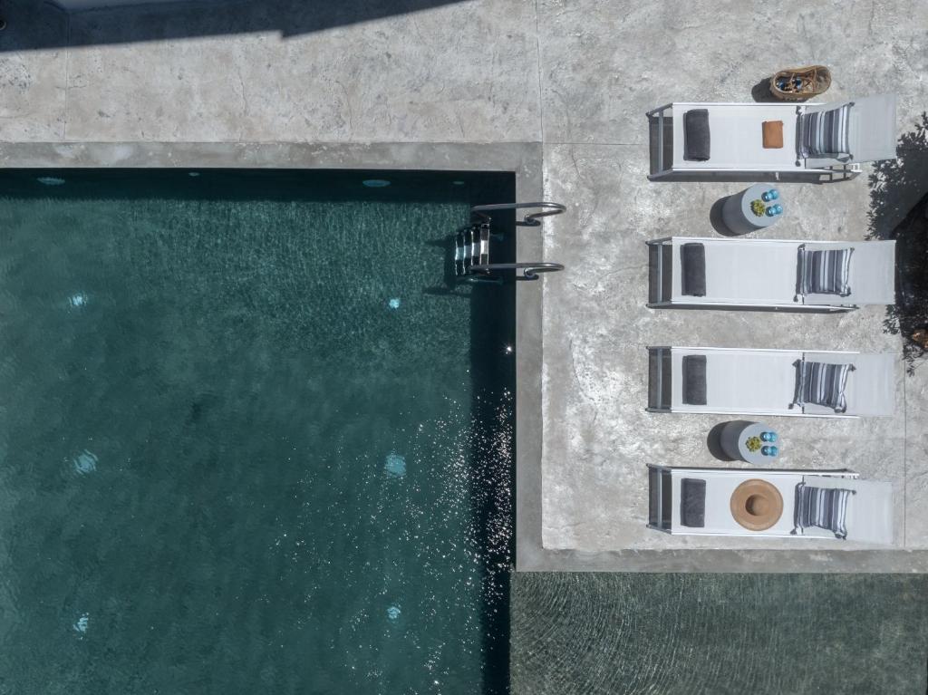 eine Draufsicht auf einen Pool mit Stühlen daneben in der Unterkunft Mons Villa in Kalathas