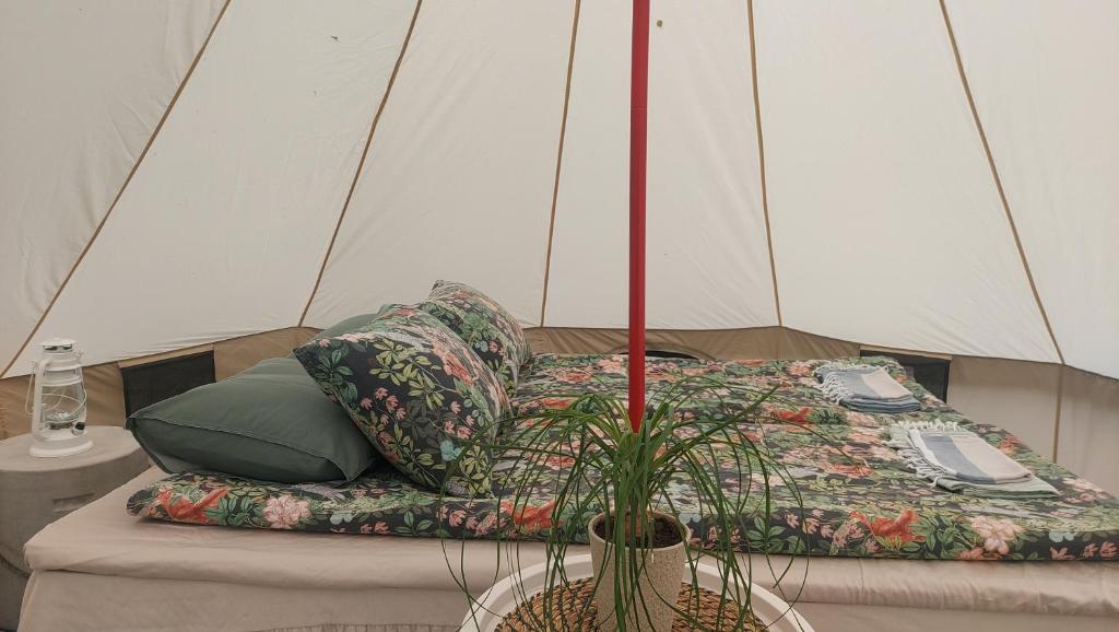 un letto in una tenda con un telecomando sopra di Glamping & Floating Sauna a Rejböle
