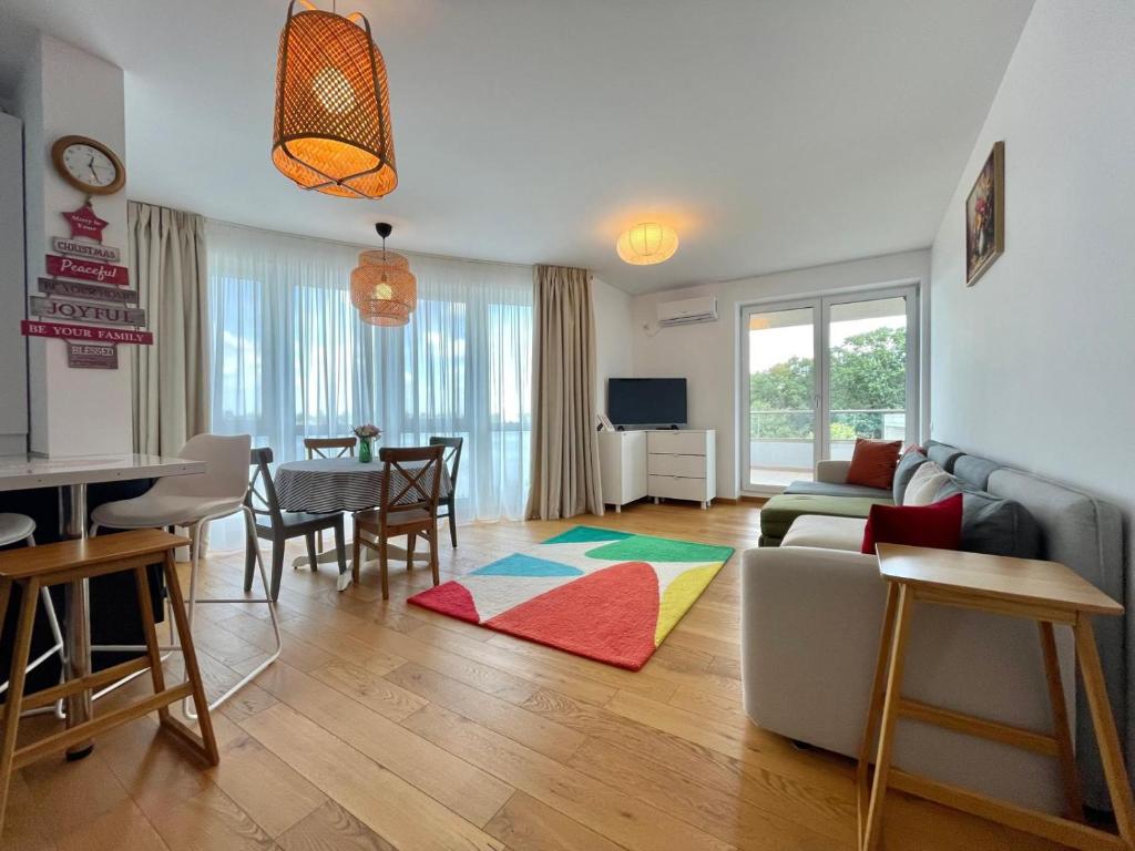 a living room with a couch and a table at Apartment No 207 Lebada Lake Residence in Pantelimon