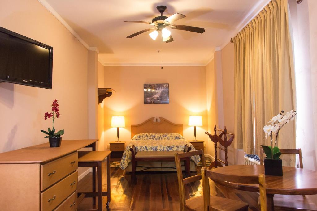 a bedroom with a bed and a desk and a table at The Durban Hotel Guyana INC. in Georgetown