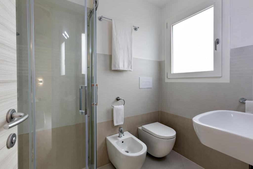 a bathroom with a toilet and a sink and a shower at Hotel Borgo Dell'Orso in Palau