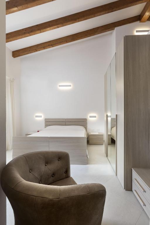 a bedroom with a bed and a chair at Hotel Borgo Dell'Orso in Palau