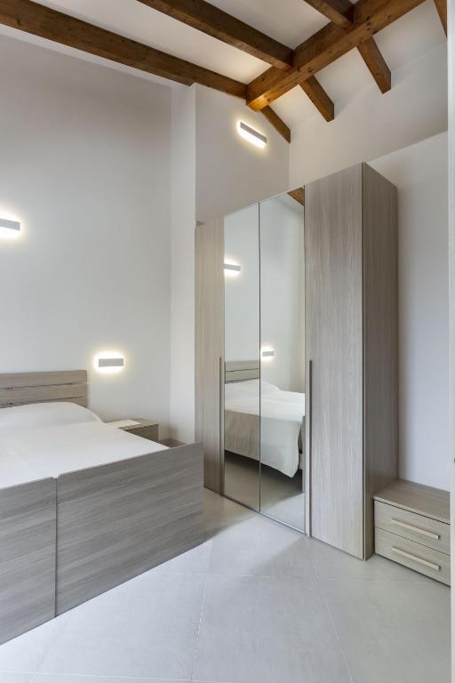 a bedroom with a bed and a mirrored cabinet at Hotel Borgo Dell'Orso in Palau