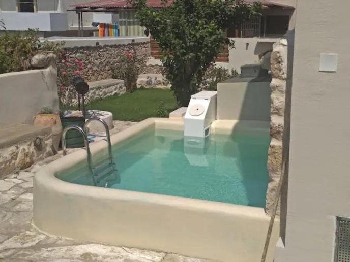 a pool of water with a chair in a yard at NiAmalFi Apartments in Atsipopoulo
