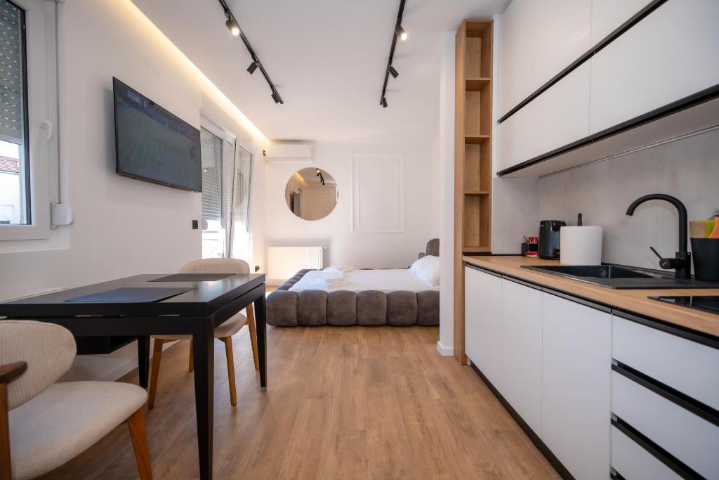 a kitchen and a living room with a table at Zuma Lux Apartments in Kragujevac