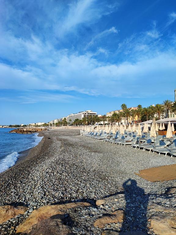 l'ombre d'une personne debout sur une plage dans l'établissement Appartement 3 PIECES NICE Promenade, à Nice