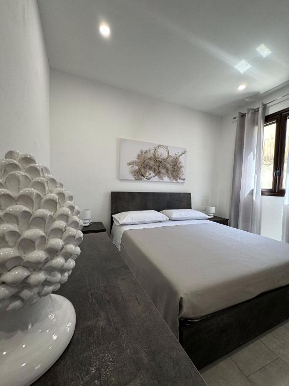 a bedroom with a large bed and a large vase at La dimora delle rose in Noto