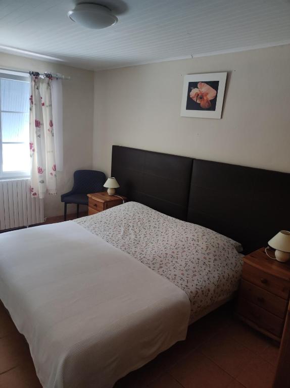 une chambre avec un grand lit blanc et une fenêtre dans l'établissement Douce France 82, à Saint-Nicolas-de-la-Grave