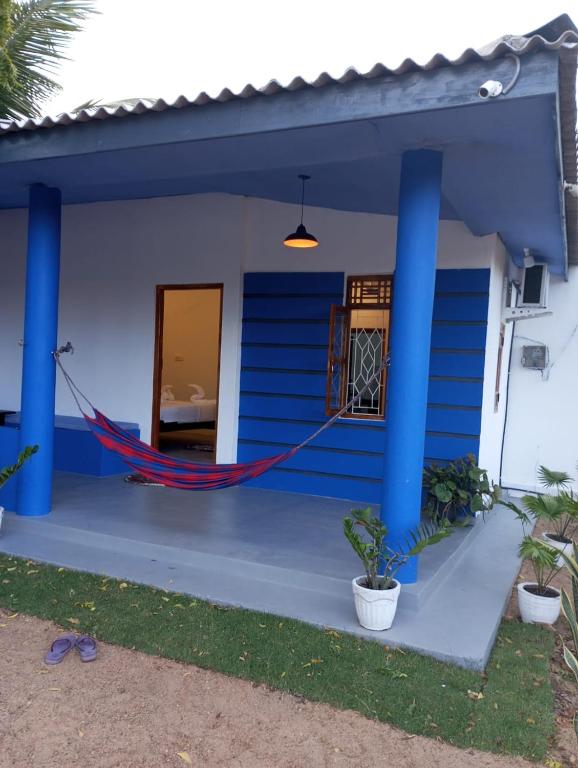 a house with a hammock in front of it at Lilly Pilly Villa Arugambay in Arugam Bay