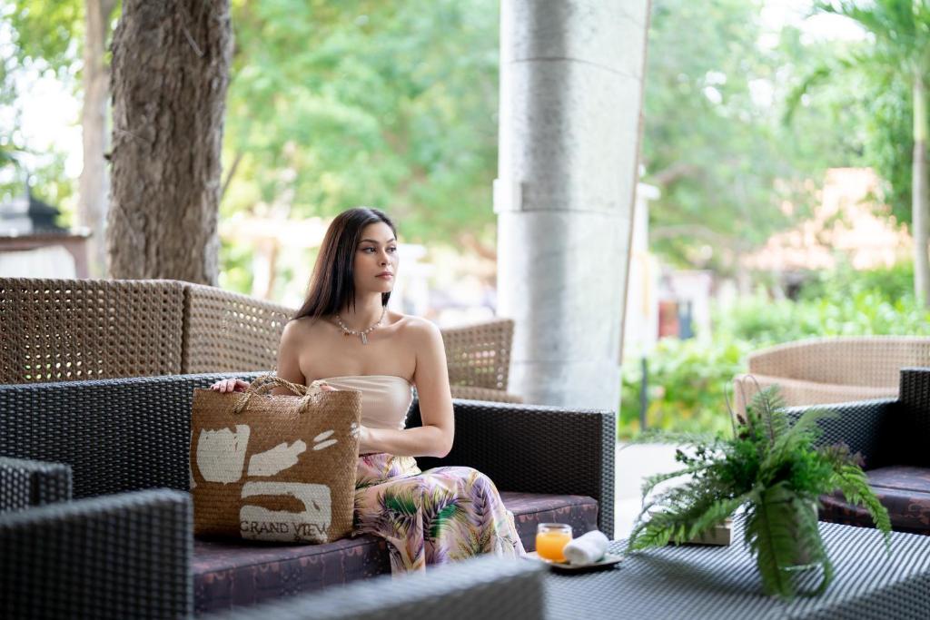 a woman sitting on a chair on a patio at Ao Cho Grandview Hideaway Resort in Ko Samed