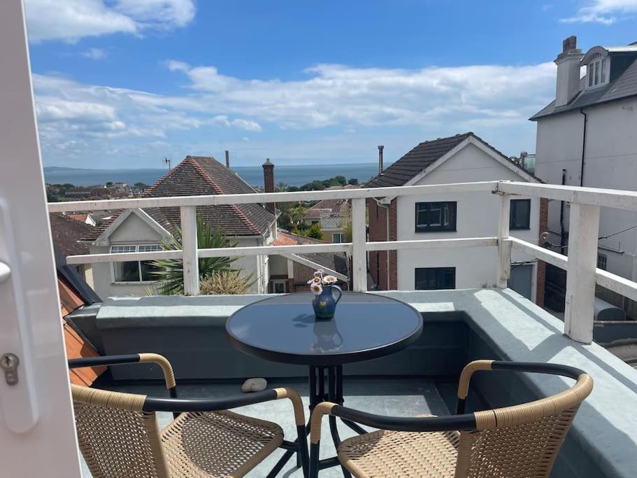 a patio with a table and chairs on a balcony at Little Briar in Lyme Regis