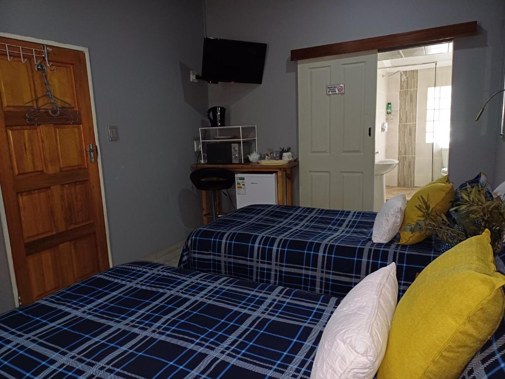 a room with a bed with a blue and yellow at WHY NOT GUESTHOUSE in Bothaville