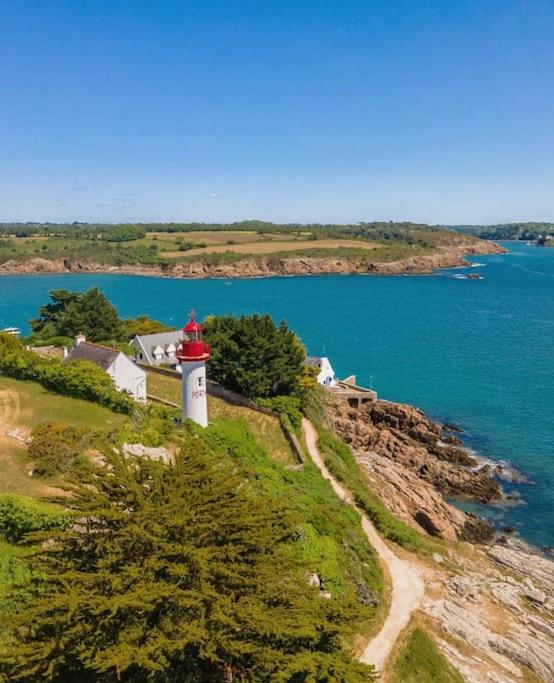 un phare sur une colline à côté d'une masse d'eau dans l'établissement Studio à Port Manec'h - Plage et port à pied, à Névez