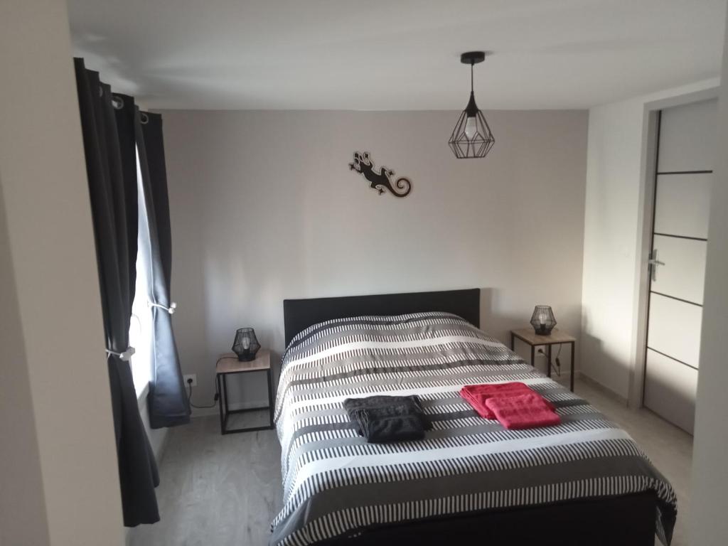 a white bedroom with a bed with two tables at Les lauriers roses in Fontvieille