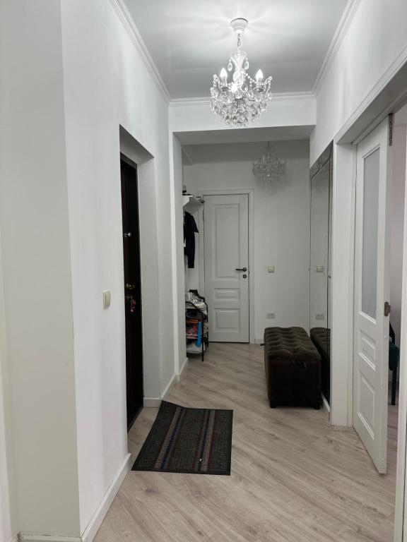 sala de estar con lámpara de araña y paredes blancas en Dzhal-29, en Bishkek