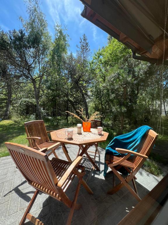 un tavolo e sedie in legno su un patio di Poilsis Urbo Nidoje a Nida