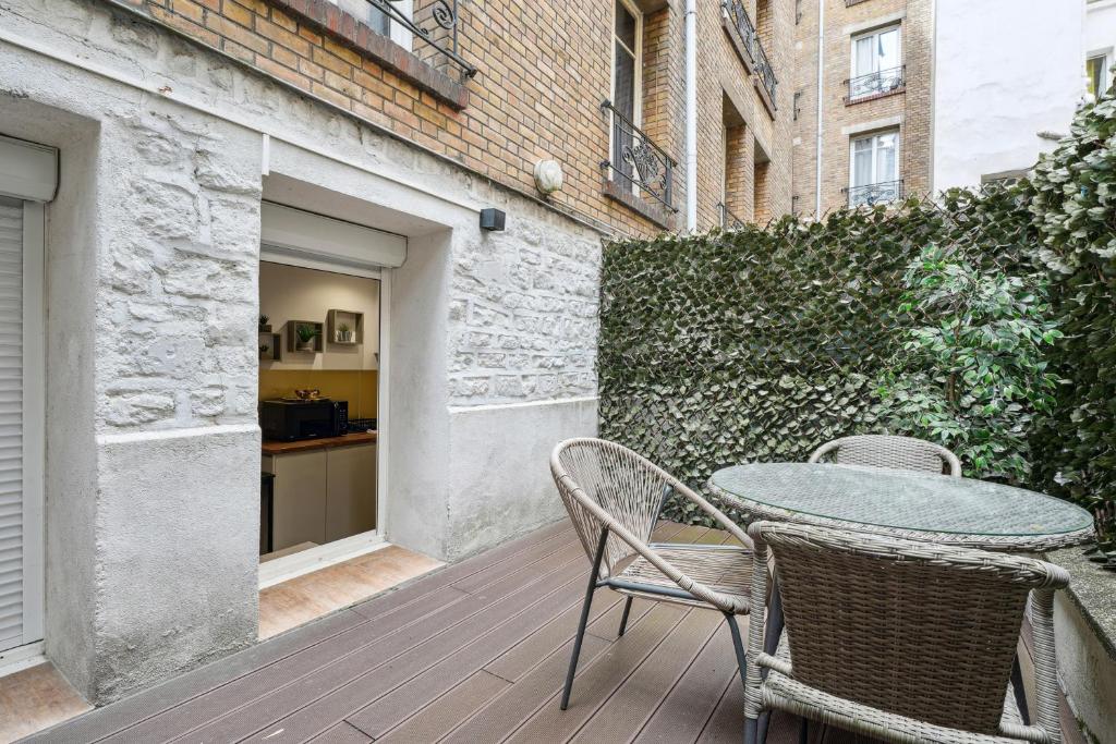 une terrasse en bois avec une table et des chaises. dans l'établissement Tour Eiffel Apartment, à Paris