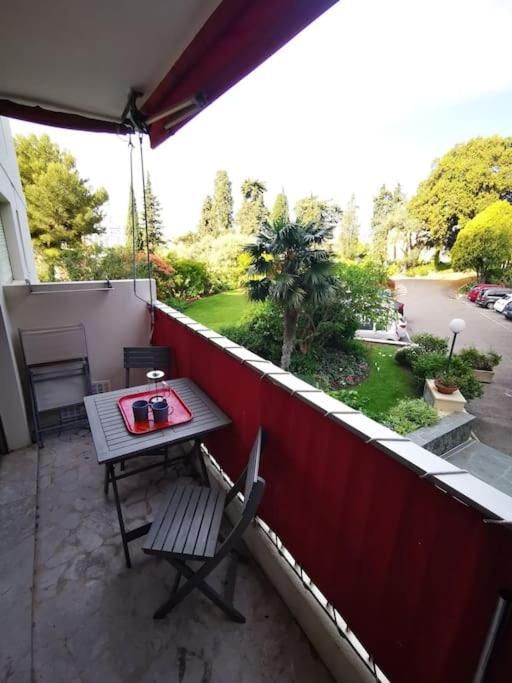 un patio avec une table et des chaises sur un balcon dans l'établissement Cosy studio,piscine,parc fleuri,résidence standing,parking, à Antibes
