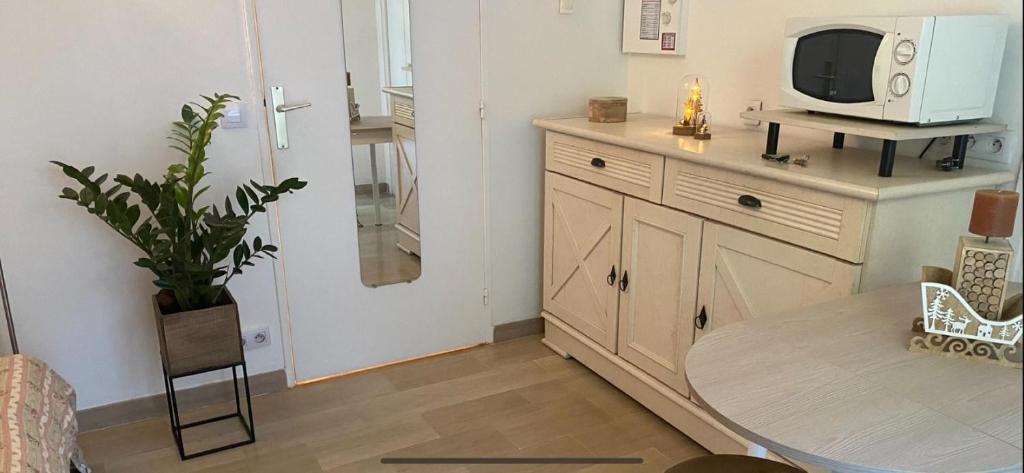 un salon avec une table et une télévision dans l'établissement Studio Rénové en Rez de Jardin Climatisé, à Cannes