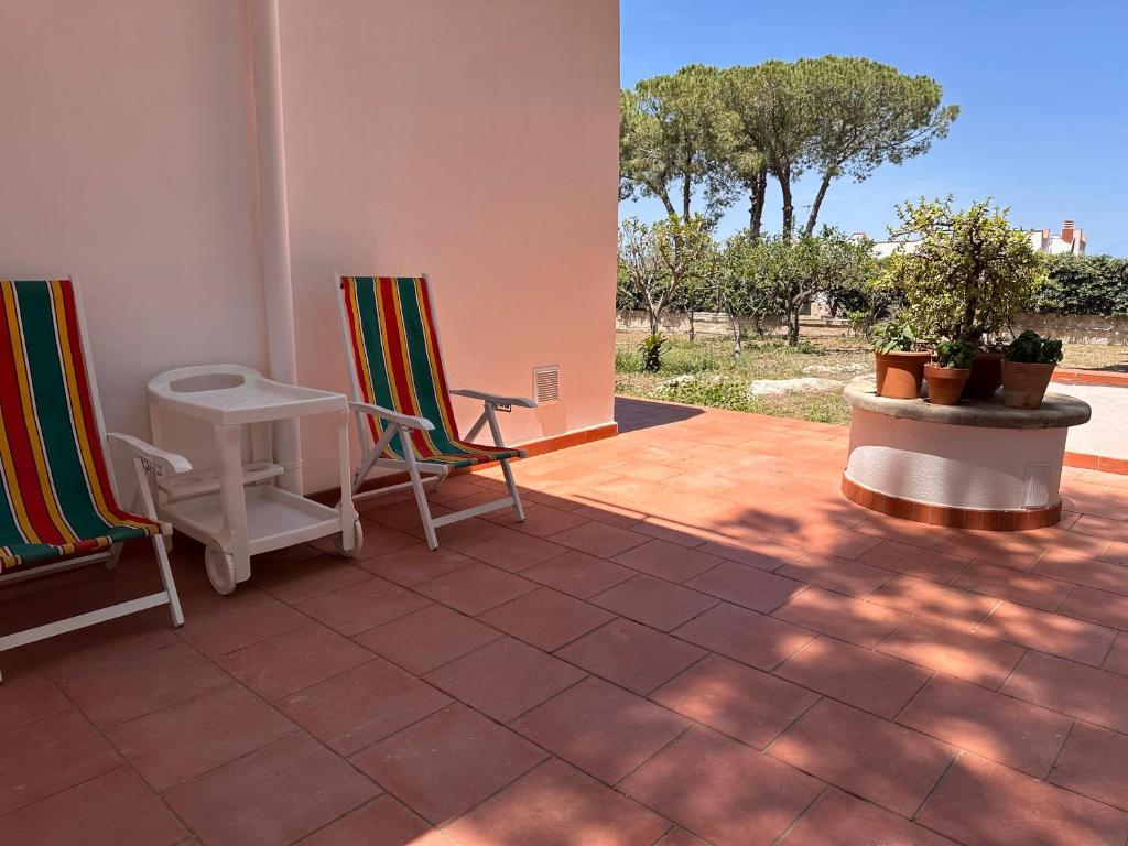 two chairs and a table on a patio at L'isola di Gianni by Ortigia Apartments in Plemmirio