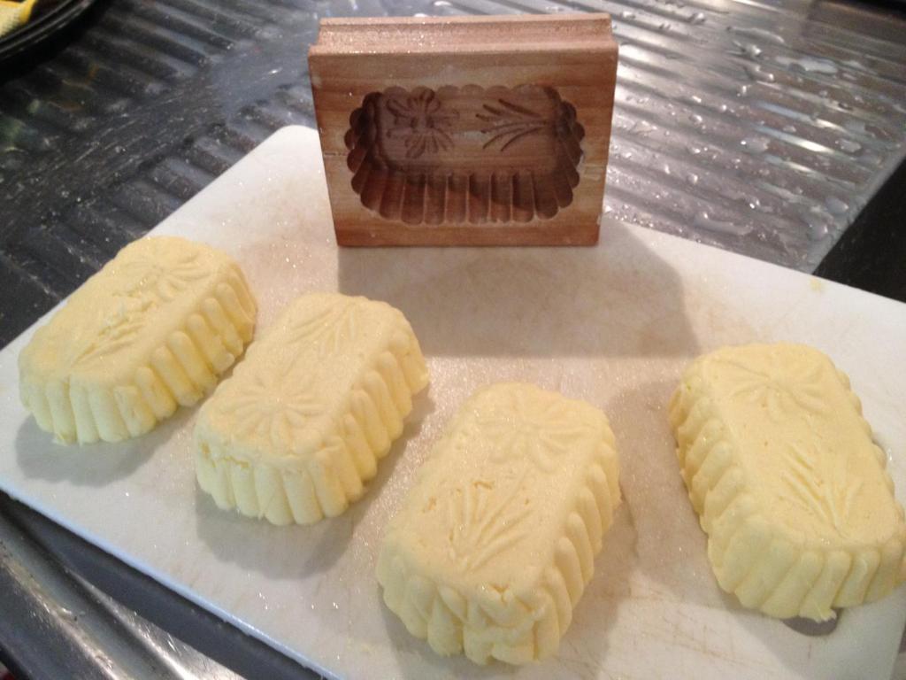 four cookies on a plate next to a box of chocolate at Agriturismo Maso Larciunei in Selva di Val Gardena