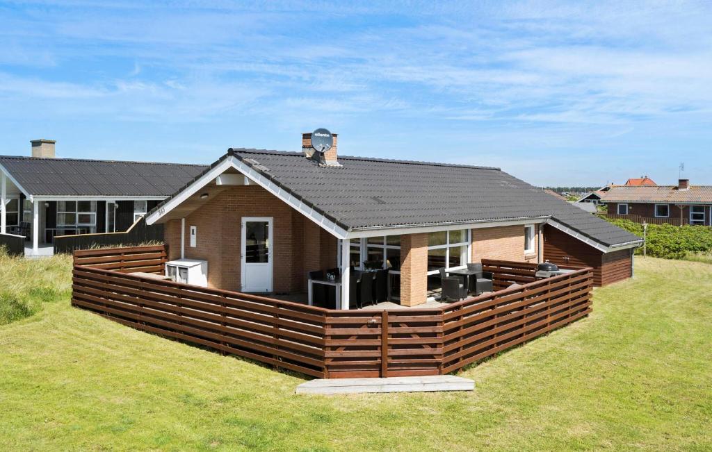 a house with a large deck in the yard at Holiday Home Vejlby Klit in Harboør