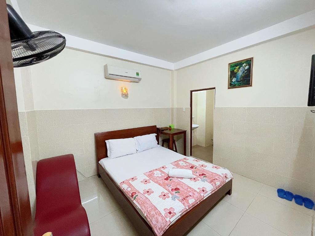 une chambre avec un lit et une chaise rouge dans l'établissement THANH HẰNG MOTEL, à Xã Thắng Nhứt