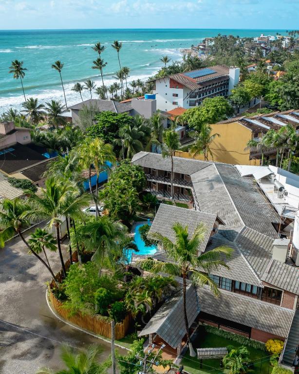 an aerial view of a resort with palm trees and the ocean at Pousada Pérola do Porto in Porto De Galinhas
