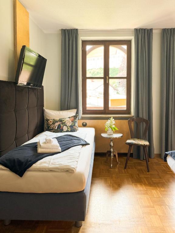 a bedroom with a bed with a television on top of it at Villa Fantasia Budget Boutique Hotel in Füssen