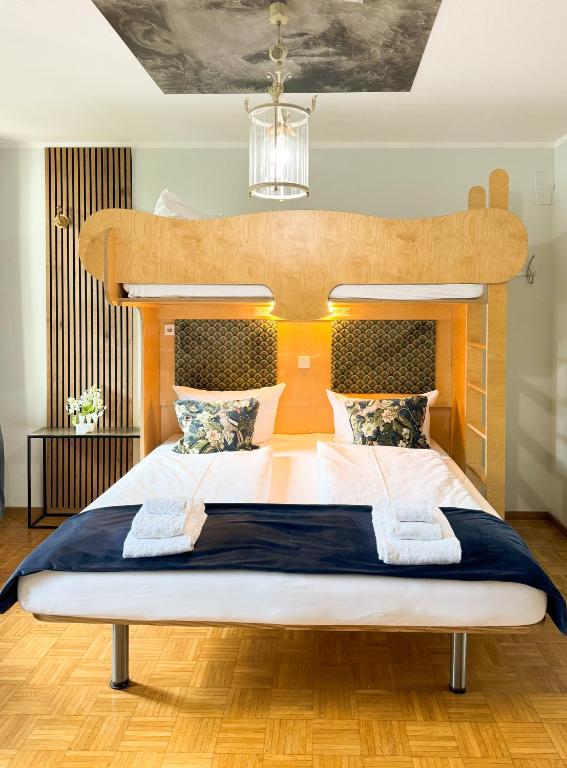 a bedroom with a large bed with a wooden headboard at Villa Fantasia Budget Boutique Hotel in Füssen