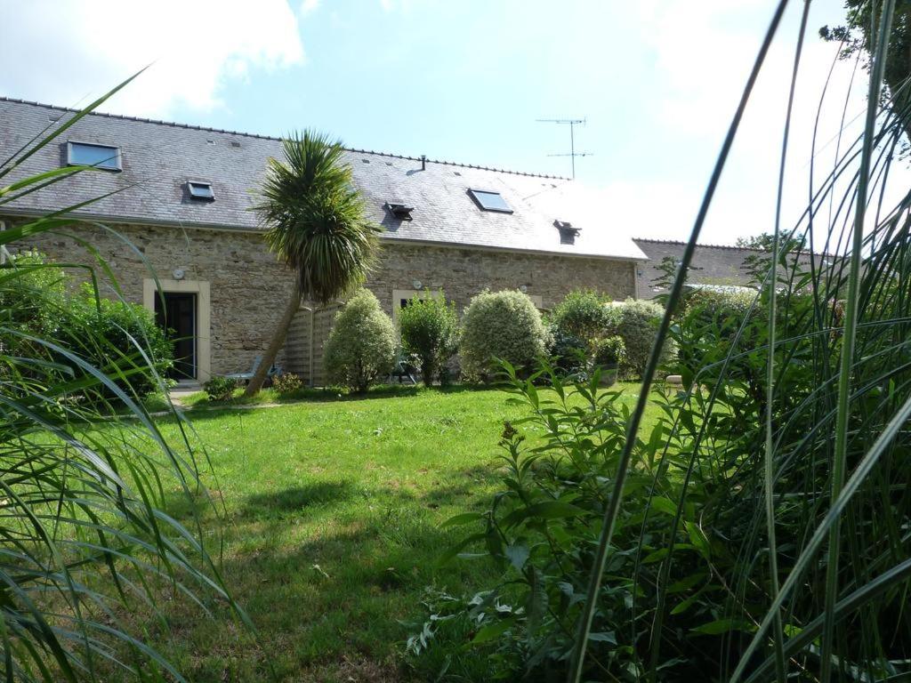 una casa in pietra con una palma nel cortile di Vergers de Kerguen a Quimper