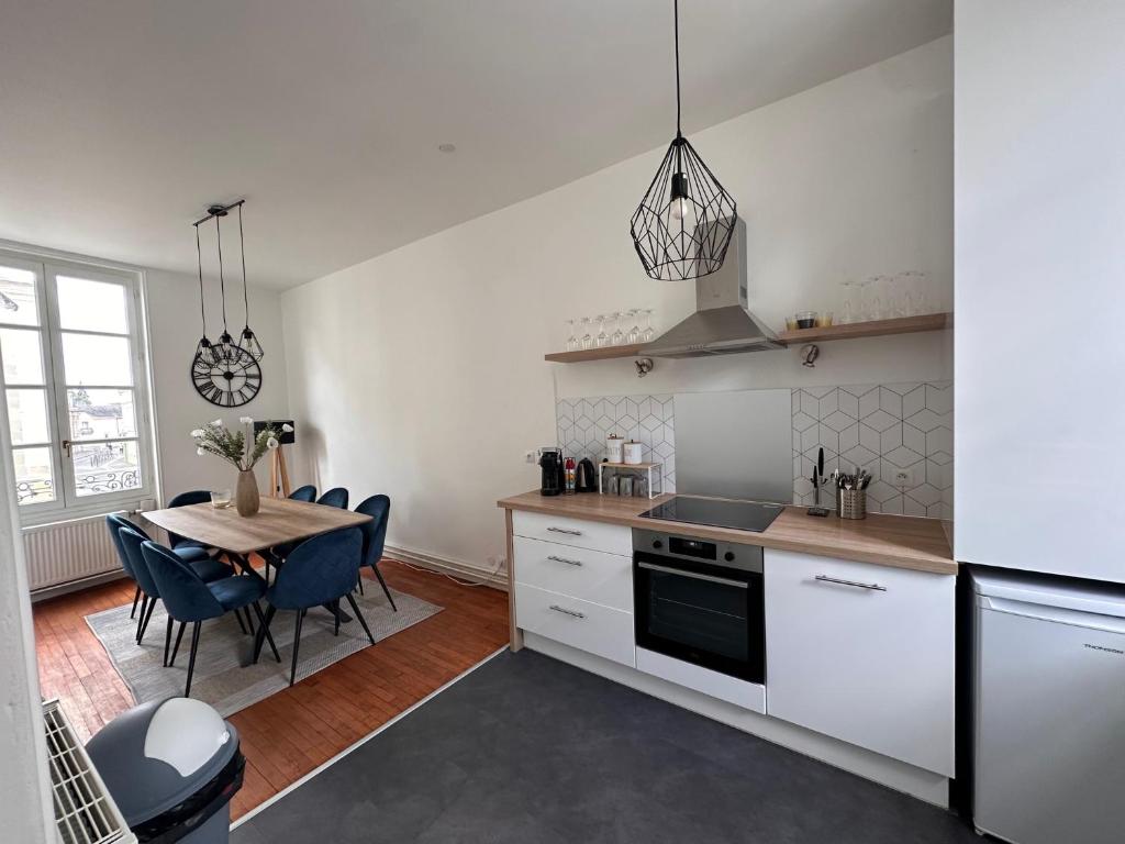 eine Küche mit Tisch und ein Esszimmer in der Unterkunft Appartement cœur de ville in La Flèche