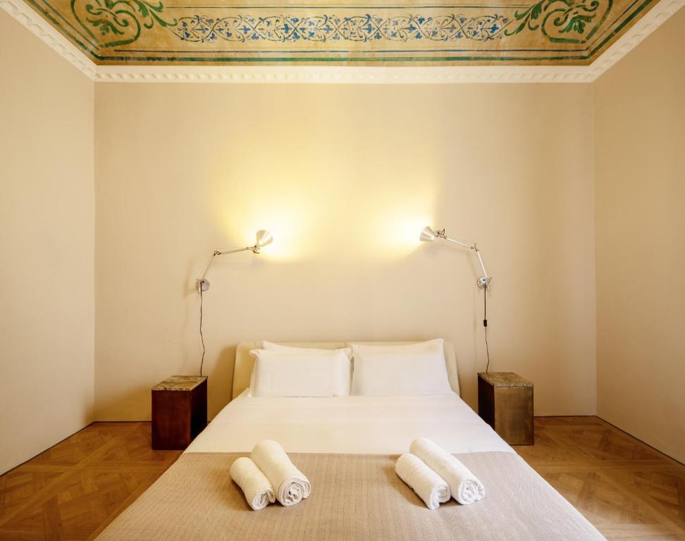 ein Schlafzimmer mit einem Bett mit zwei Handtüchern darauf in der Unterkunft Domus Dionisio Apt by Addler House Ospitality in Syrakus