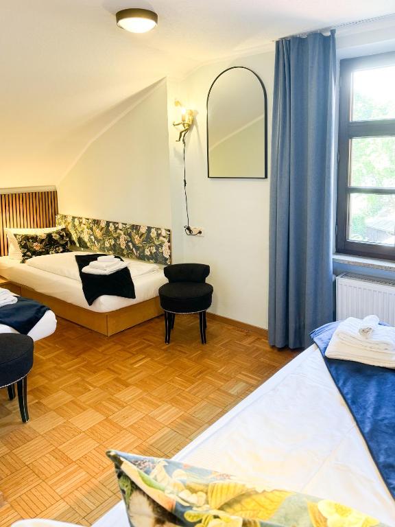 a hotel room with two beds and a window at Villa Fantasia Budget Boutique Hotel in Füssen