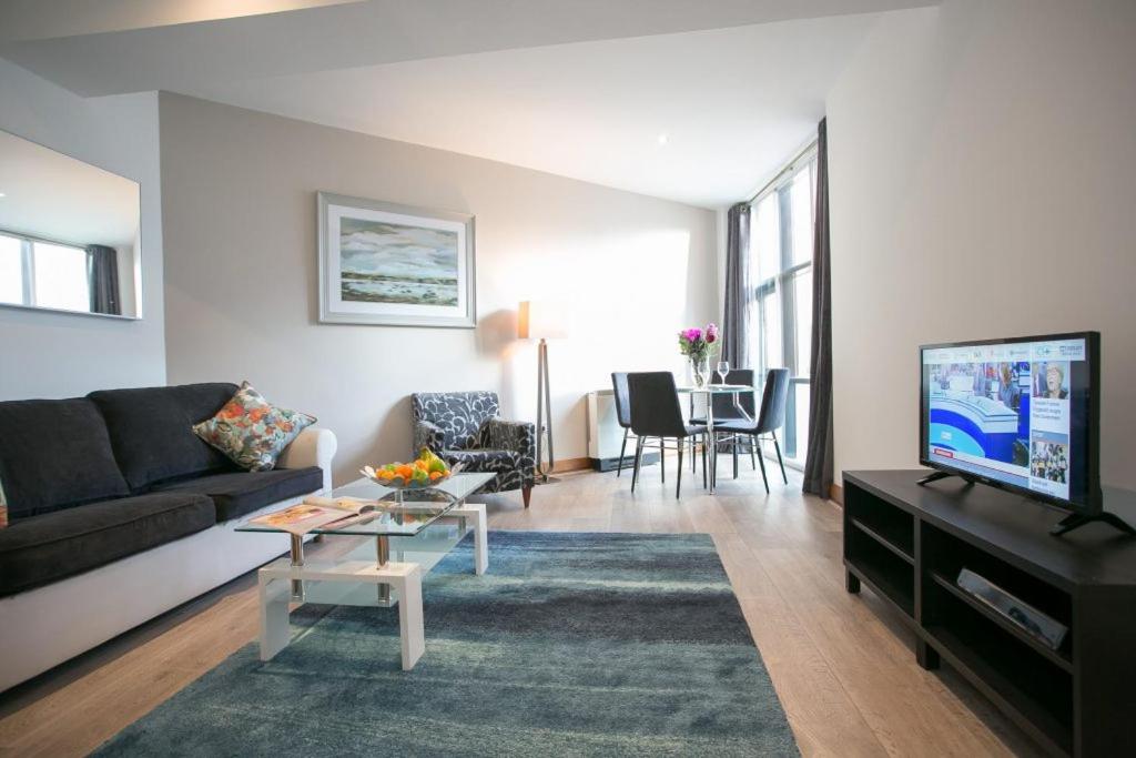 a living room with a couch and a tv at Parnell Boulevard Apartments in Dublin