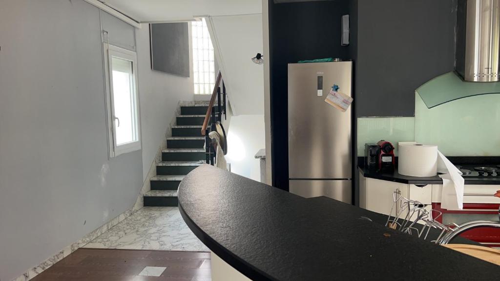 una cucina con tavolo e frigorifero di La Vivaraize a Saint-Étienne