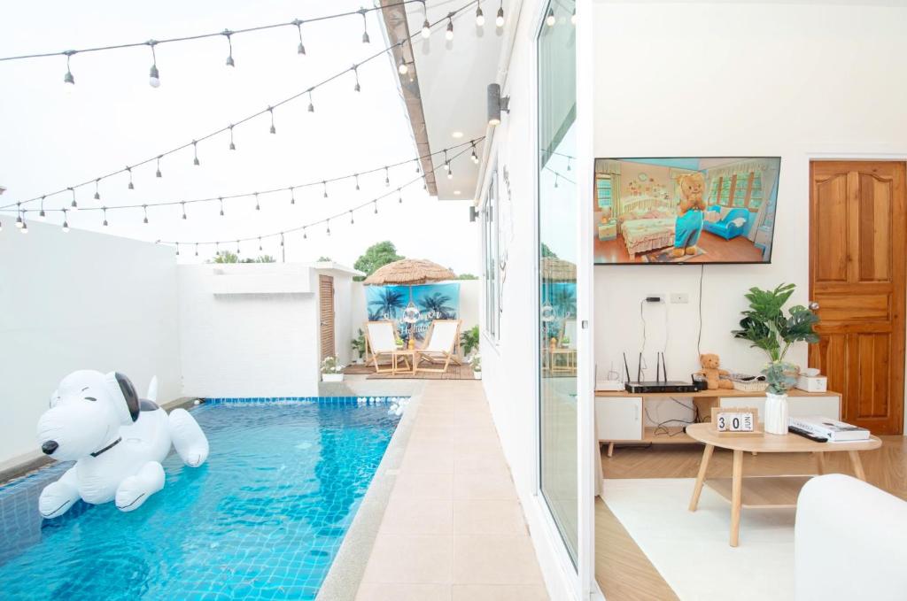 ein Haus mit einem Pool in der Mitte eines Wohnzimmers in der Unterkunft Teddy House Cozy 3BD Poolvilla near Jomtien beach in Ban Huai Yai