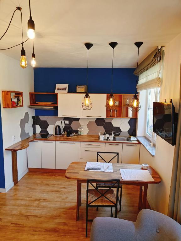 a kitchen with a table and a blue wall at Achilla Bed & Breakfast in Český Krumlov