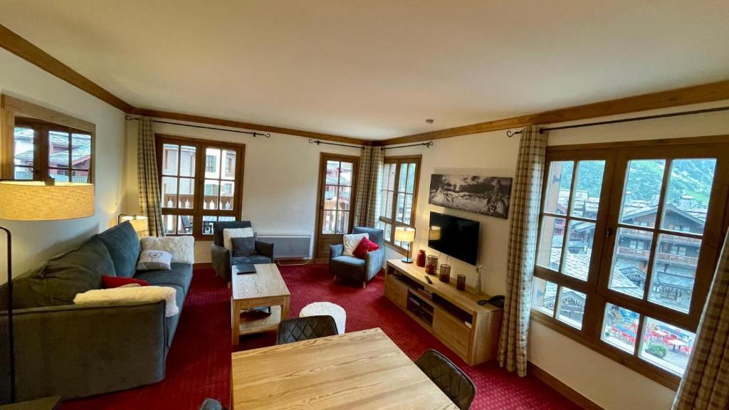 un salon avec un canapé et une table dans l'établissement Arc 1950 - Appt 2CH - 6 pers - Rés 5* luxe - Piscine, sauna, hamman, jacuzzi - Classé 5 cristaux Paradiski, à Arc 1950