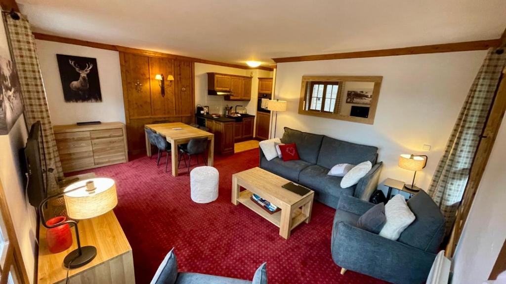 un salon avec un canapé et une table dans l'établissement Arc 1950 - Appt 2CH - 6 pers - Rés 5* luxe - Piscine, sauna, hamman, jacuzzi - Classé 5 cristaux Paradiski, à Arc 1950