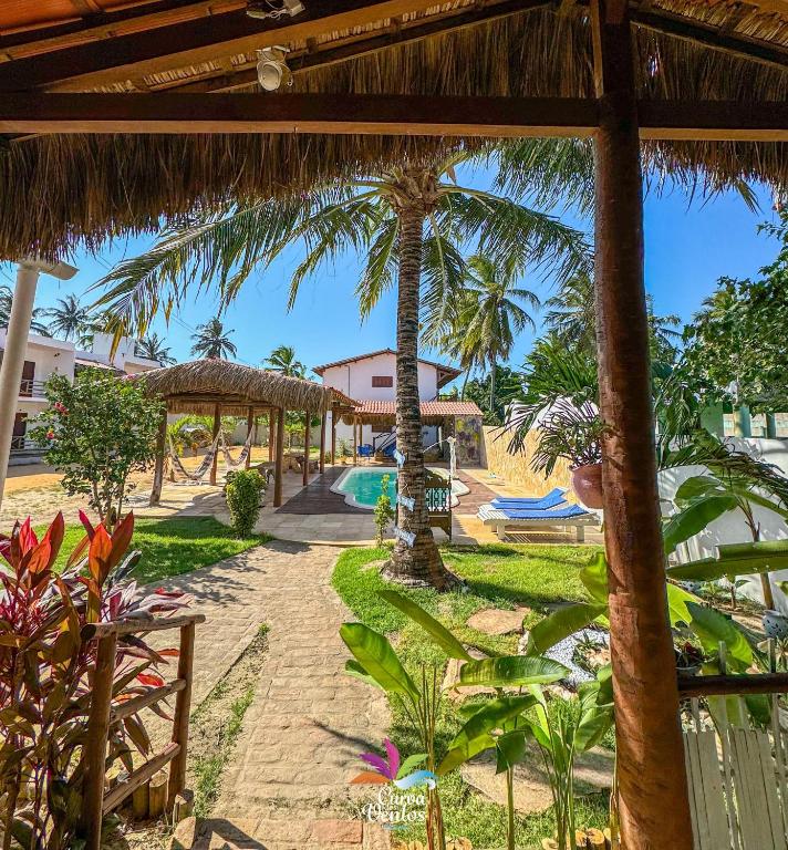 a view of a resort with a pool and palm trees at Pousada Curva dos Ventos-Próximo à praia com café da manhã em Icaraí de Amontada in Icaraí