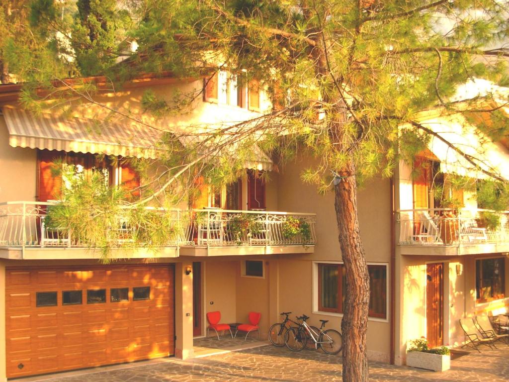 una casa con un albero di fronte di Residence Le Palme appartamenti a Malcesine