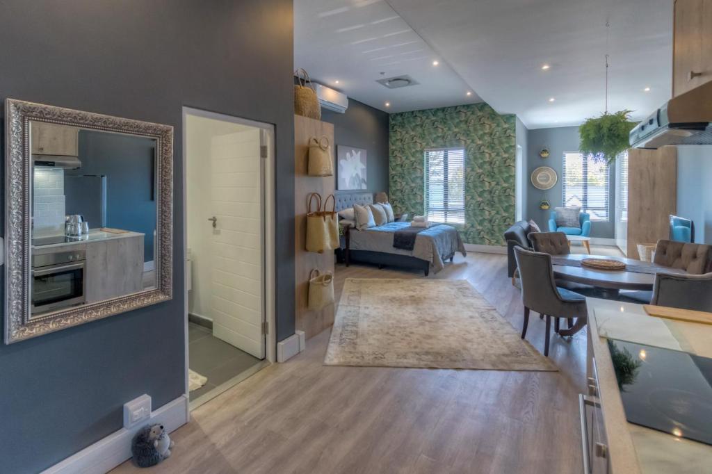 a living room with a kitchen and a dining room at Trebuchet Studio Apartment in Somerset West
