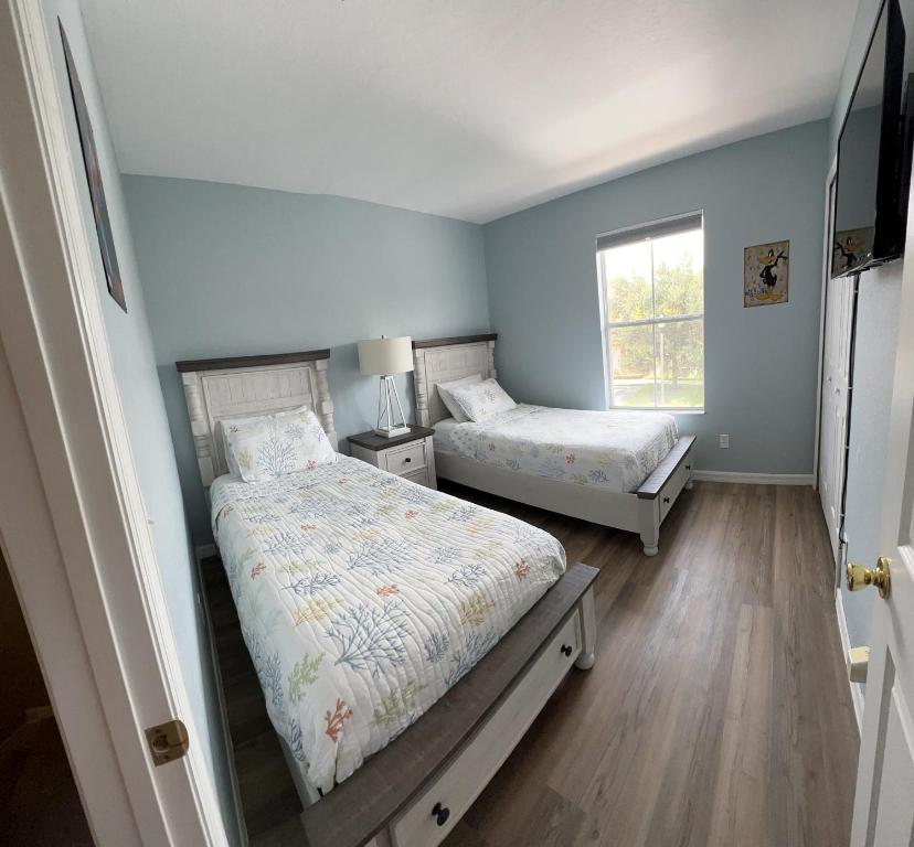 a bedroom with two beds and a window at Camaro in Orlando