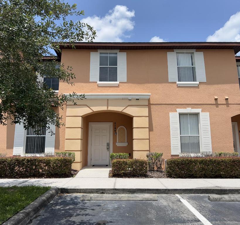 a brown house with a white door at Camaro in Orlando